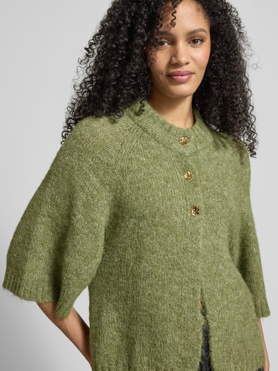 Frauenmodel trägt Strickjacke mit 1/2-Arm Modell 'Benutta Fluffy' von Neo Noir in Grün, Material-Mix mit Baumwoll-Anteil, Relaxed-Fit, Rundhalsausschnitt, Knopfverschluss, Nahaufnahme Oberkörper.