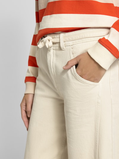 Frauenmodel trägt Jeans mit Bindegürtel von Jake*s Casual aus reiner Baumwolle, Wide-Fit, Eingrifftaschen, Nahaufnahme Oberkörper.