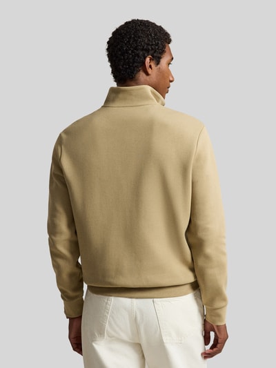 Männermodel trägt beigen Relaxed Fit Troyer aus Baumwoll-Mix von Polo Ralph Lauren, glatte Textur, Ganzkörperansicht Rückansicht. Herren Troyer