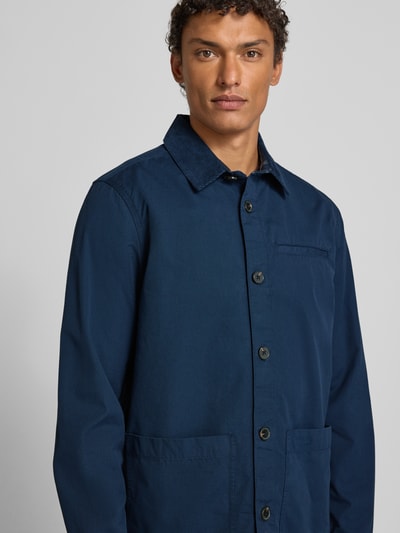 Männermodel trägt Regular Fit Hemdjacke aus reiner Baumwolle von Barbour in Optik: Unifarben mit Umlegekragen, Langarm, Eingrifftaschen, Nahaufnahme Oberkörper.