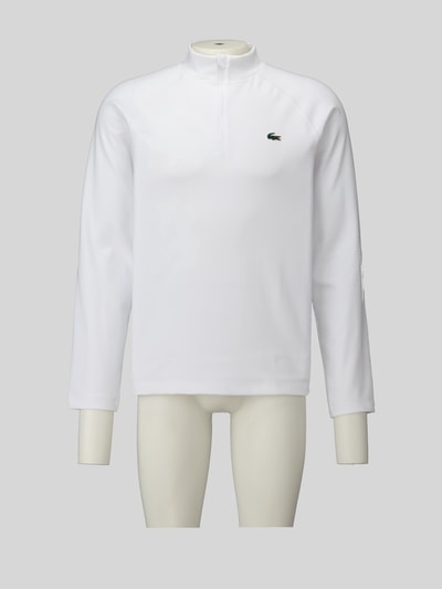 Männermodel trägt weißes Regular Fit Sport-Langarmshirt mit Ultra-Dry-Technologie von Lacoste, Herren Sport-Langarmshirt, Ganzkörperansicht von vorne.