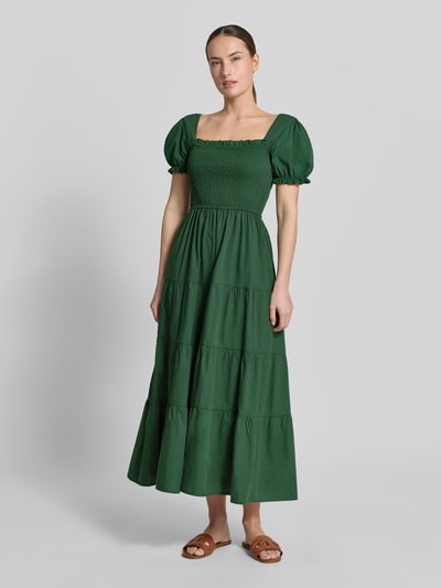 Kobiece modelka nosi długa sukienka 'Maxikleid mit Smok-Details und Karree-Ausschnitt' od Apricot z bawełny, prostokątny dekolt z falbanami, rękawy z falbanami, taliowany fason, długość tyłu w rozmiarze S: 116 cm, szerokość w rozmiarze S: 32 cm, długość rękawów w rozmiarze S: 21 cm, kolor zielony, tekstura gładka, widok całościowy z przodu.