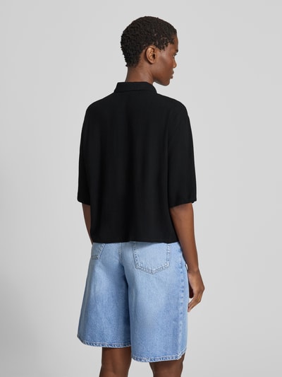 Vrouwenmodel draagt Bluse mit Kentkragen und Knopfleiste van Jake*s Casual in zwart, loose fit, 3/4-mouw, ruglengte 55 cm, mouwlengte 31 cm, ganzkörperaanzicht achteraan.
