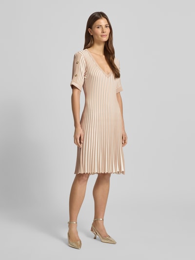 Frauenmodel trägt Minikleid mit gerippten Abschlüssen von LIU JO SPORT aus Viskose-Mix in Beige, tailliert, V-Ausschnitt, Label-Print, Ganzkörperansicht von vorne.