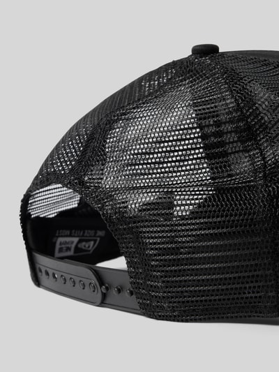 Produktfoto, schwarze Basecap mit Label-Detail von New Era aus Baumwolle, semitransparenter Einsatz, verstellbarer Verschluss, Detailaufnahme.