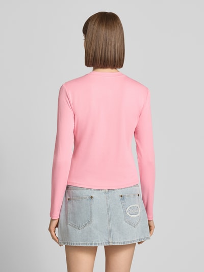 Kobiece model prezentuje kardigan z mieszanki bawełny i modalu OH APRIL Model 'Tima' w kolorze jasnoróżowym, krój slim fit, okrągły dekolt, listwa guzikowa, wyhaftowane logo, długość tyłu w rozmiarze S: 47 cm, długość rękawów w rozmiarze S: 61 cm, widok całej sylwetki od tyłu.
