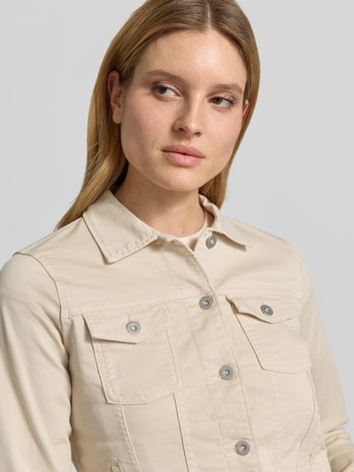 Frauenmodel trägt Regular Fit Jeansjacke aus Baumwoll-Mix von Tom Tailor in Beige mit Umlegekragen und Knopfleiste, Nahaufnahme Oberkörper.