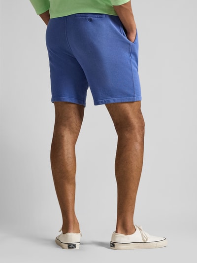Männermodel trägt Regular Fit Sweatshorts aus Baumwoll-Mix von Polo Ralph Lauren in Unifarbe Blau mit Logo-Stitching, Ganzkörperansicht Rückansicht.