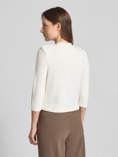 Vrouwenmodel draagt Strickjacke mit Knopfleiste van Windsor, pure scheerwol, regular fit, steekzakken, ronde hals, 3/4-mouw, geribde boorden, ruglengte 43 cm, mouwlengte 42 cm, gekleurde achterkant, geheelopname achteraan.