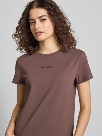Frauenmodel trägt T-Shirt mit Rundhalsausschnitt und Logo-Stitching von Review, Baumwoll-Mix mit Stretch, körpernah, Nahaufnahme Oberkörper.