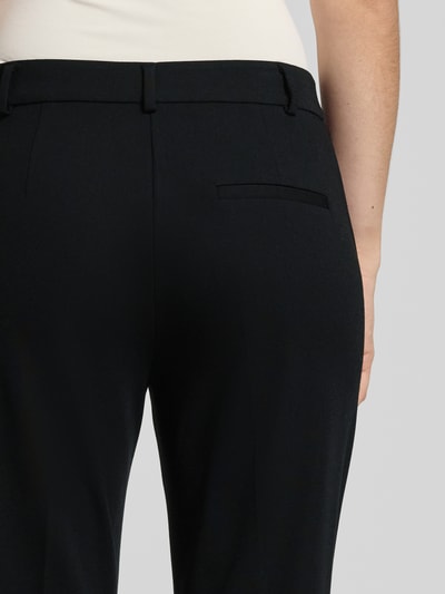 Frauenmodel trägt Stoffhose mit Gesäßtasche von Comma, schwarzer Viskose-Mix mit Stretch-Anteil, lockerer Schnitt, Detailaufnahme Rückansicht.