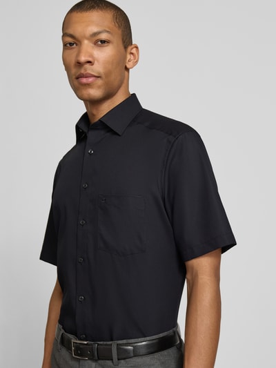 Männermodel trägt Regular Fit Freizeithemd mit Kentkragen von OLYMP in Schwarz, Reine Baumwolle, Kurzärmelig, Nahaufnahme Oberkörper.