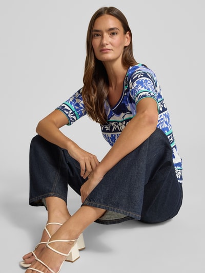 Frauenmodel trägt Damen T-Shirt mit Rundhalsausschnitt von Betty Barclay aus Baumwoll-Mix mit Stretch-Anteil, Regular-Fit, Allover-Muster, Rückenlänge bei Größe 36: 44 cm, vorrangig in Blau und Weiß, Allover-Muster mit floralen und geometrischen Elementen, glatte Textur, Ganzkörperansicht von vorne.