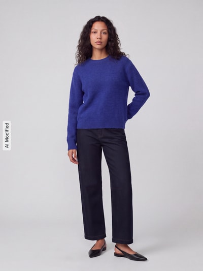 Frauenmodel trägt Regular Fit Pullover mit Woll-Anteil Modell 'ALLY' von PIECES in Dunkelblau, kombiniert mit schwarzer Hose, Ganzkörperansicht von vorne, KI-modifiziertes Bild.