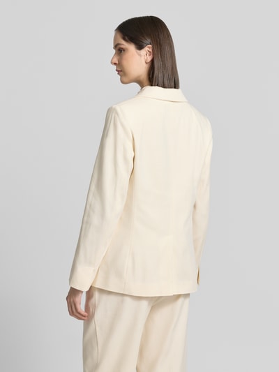 Frauenmodel trägt Blazer mit Pattentaschen Modell 'Nulani' von Someday in hellem Beige, glatte Textur, Rückenansicht, Ganzkörperansicht. Material-Mix mit Baumwoll-Anteil, Straight Fit, Reverskragen, Knopfverschluss, Rückenlänge 68 cm, Brustweite 44 cm, Ärmellänge 62 cm.