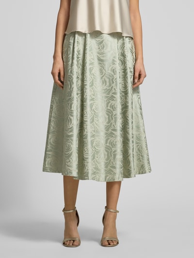 Frauenmodel trägt Midirock aus Satin mit Eingrifftaschen von Rinascimento, florales Muster, hellgrün, A-Linie, Nahaufnahme Unterkörper.