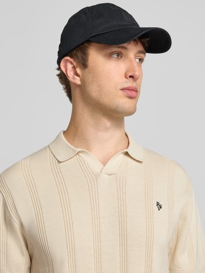 Mężczyznamodel nosi Regular Fit Poloshirt mit Logo-Stitching od REVIEW z bawełny, ażurowe hafty, krótki rękaw, długość tyłu 56 cm, Nahaufnahme górnej części ciała.