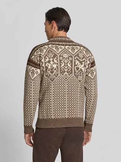 Männermodel trägt Strickpullover mit Stehkragen von Dale of Norway in Braun und Beige mit traditionellem Muster, Ganzkörperansicht Rückansicht. Gerader Schnitt, Label-Patch, gerippte Abschlüsse, Rückenlänge 66 cm, Ärmellänge 58 cm, überschnittene Schultern.
