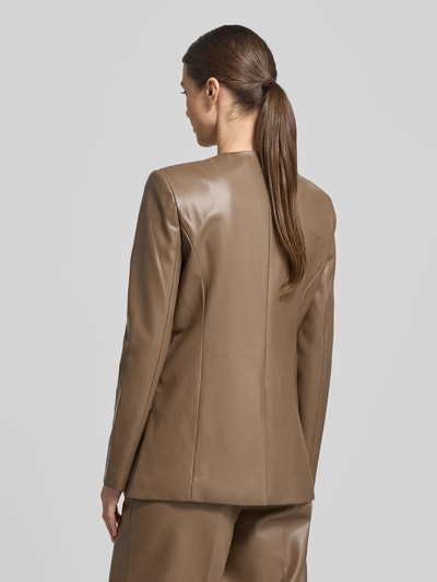 Kobiece model prezentuje kurtkę Slim Fit Jacke in Leder-Optik Modell 'Doma' od STAND STUDIO, beżowy materiał skóropodobny, okrągły dekolt, kieszenie z patką, długość tyłu w rozmiarze 36: 70 cm, szerokość ramion w rozmiarze 36: 40 cm, szerokość klatki piersiowej w rozmiarze 36: 46 cm, długość rękawów w rozmiarze 36: 64 cm; pełen widok sylwetki od tyłu.