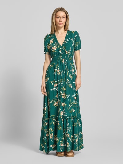 Modelka nosi Maxikleid aus Viskose mit V-Ausschnitt von Apricot, zielony, kwiatowy wzór, A-linia, elastyczna talia, S, czyste włókno wiskozowe, długość tyłu 123 cm, szerokość w rozmiarze S 32 cm, długość rękawa 22 cm, widok całej sylwetki z przodu.