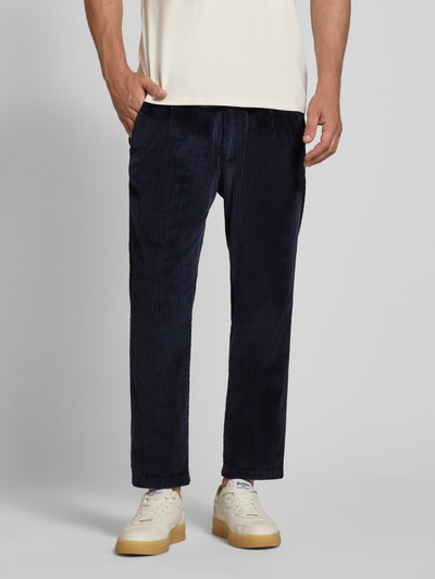 Männermodel trägt dunkelblaue Straight Fit Hose aus Baumwoll-Mix Modell 'Chasy' von DRYKORN mit Cord-Optik, Nahaufnahme Unterkörper. Kontext: Herren Hose, elastischer Baumwoll-Mix, Gesäßtaschen, Knopf- und Reißverschluss, Bundweite 40 cm, Innenbeinlänge 71 cm.