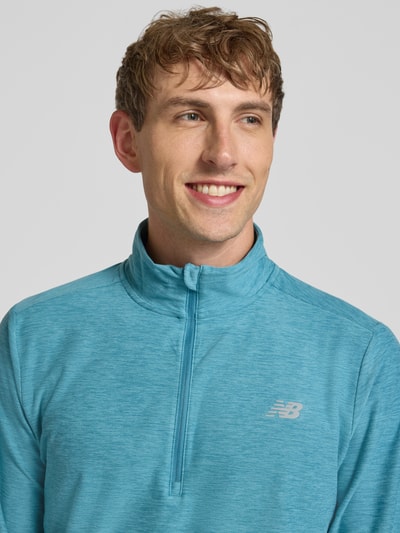 Męski model nosi Regular Fit Sweatshirt mit Troyer-Kragen od New Balance, elastyczna mieszanka materiałów, krój regular fit, nadruk z logo, długość tyłu w rozmiarze M: 69 cm, zbliżenie na górną część tułowia