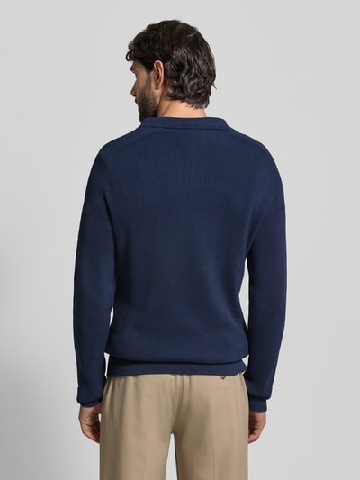 Männermodel trägt Strickpullover aus reiner Baumwolle Modell 'NORDIN' von Casual Friday in Dunkelblau, Rippstrick-Optik, Ganzkörperansicht Rückansicht.