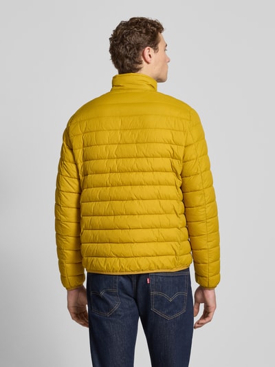 Mężczyzna nosi Steppjacke mit Reißverschluss od MCNEAL, żółty kolor, regular fit, widok całej sylwetki z tyłu, opis kontekstu produktu.