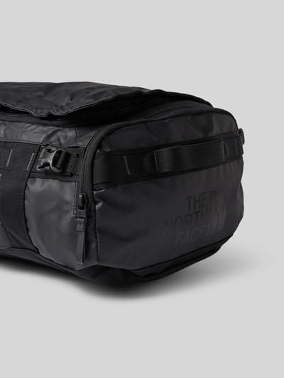 Produktfoto, Duffel Bag mit Logo-Print Modell 'Voyager' von The North Face in Schwarz mit glatter Oberfläche, Reißverschluss und verstellbaren Schulterriemen, rechteckige Form, Fotokontext: Herren Duffel Bag mit Innenfächern und Maßen 30 x 20 x 9 cm, Länge Schulterriemen 13 cm