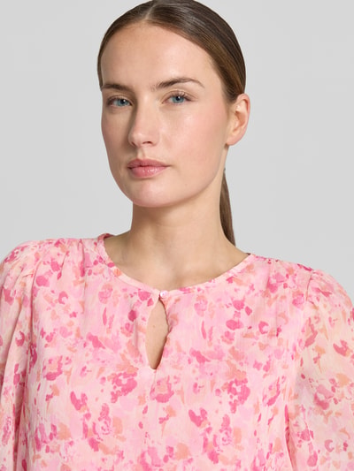 Vrouwenmodel draagt Blusenshirt mit Schlüsselloch-Ausschnitt Modell 'EMMA' van Vila, regular fit, all-over look, druppelvormige hals, roze en roze tinten, zachte textuur, detailopname bovenlichaam.