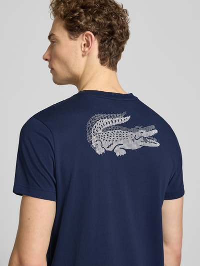 Männermodel trägt Regular Fit T-Shirt aus Baumwoll-Mix von Lacoste Sport in Dunkelblau mit Logo-Patch, Ganzkörperansicht Rückansicht.