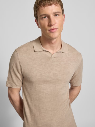 Männermodel trägt Slim Fit Poloshirt in Strick-Optik Modell 'Kane' von JACK & JONES aus reiner Baumwolle, kurzärmelig, Nahaufnahme Oberkörper.