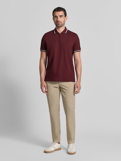 Männermodel trägt Slim Fit Poloshirt mit Kontraststreifen und Reißverschluss von MCNEAL, Baumwoll-Elasthan-Mix, Ganzkörperansicht von vorne.