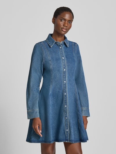 Frauenmodel trägt Tailliertes Freizeitkleid aus Baumwoll-Mix Modell 'JESSIE' von VERO MODA, jeansblauer Farbton, ausgestellter Schnitt, Ganzkörperansicht von vorne.