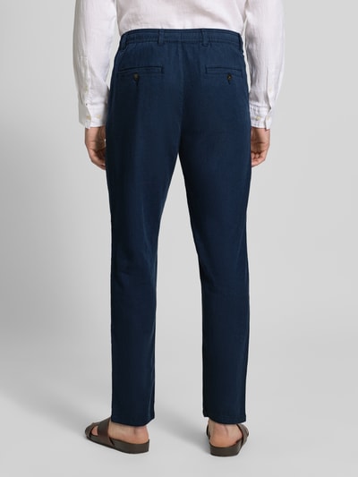 Männermodel trägt Regular Fit Hose aus Baumwoll-Leinen-Mix Modell 'BRODY' von SELECTED HOMME in Dunkelblau, Melange-Optik, Ganzkörperansicht Rückansicht.