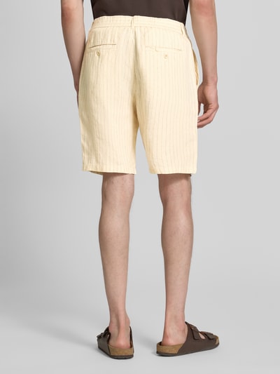 Männermodel trägt Straight Fit Leinenshorts mit Gesäßtaschen von Gant aus Reine Leinen in Hellgelb, Rückansicht, Ganzkörperansicht.