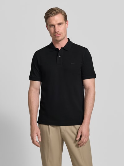 Männermodel trägt Regular Fit Poloshirt aus reiner Baumwolle Modell 'PALLAS' von BOSS, Optik: Unifarben, Ganzkörperansicht von vorne.