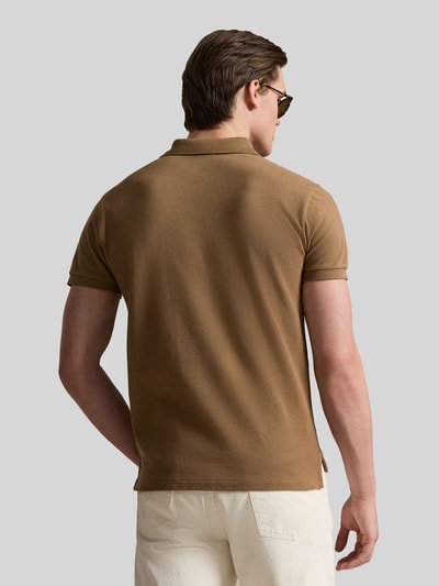 Mężczyznamodel nosi Regular Fit Poloshirt aus reiner Baumwolle von Polo Ralph Lauren, brązowy, pikowany materiał, krój regular fit, widok całej sylwetki z tyłu.