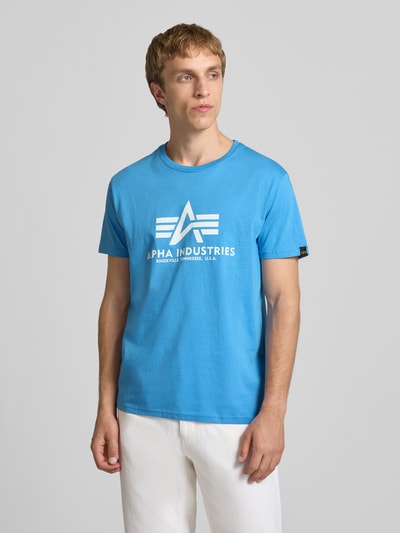 Mannenmodel draagt T-Shirt met Logo en Rundhalsausschnitt van Alpha Industries, blauwe katoen, regular fit, witte opdruk, vooraanzicht heuphoogte