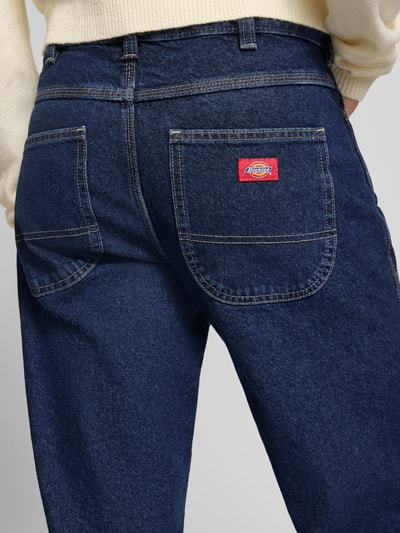 Männermodel trägt Straight Fit Jeans im 5-Pocket-Design von Dickies, reine Baumwolle, dunkelblau, Detailaufnahme Rückansicht.