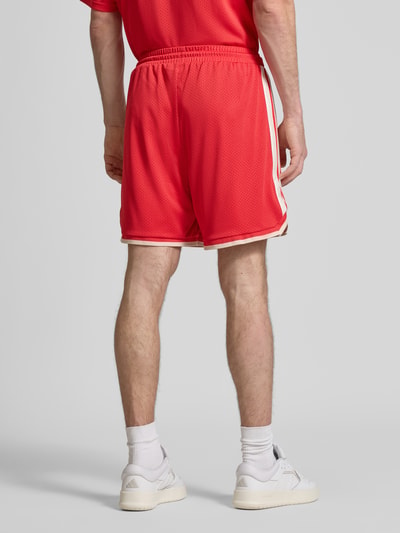 Männermodel trägt Shorts mit elastischem Bund und Kordelzug von adidas Sportswear in Rot, Logo-Print, Ganzkörperansicht Rückansicht.