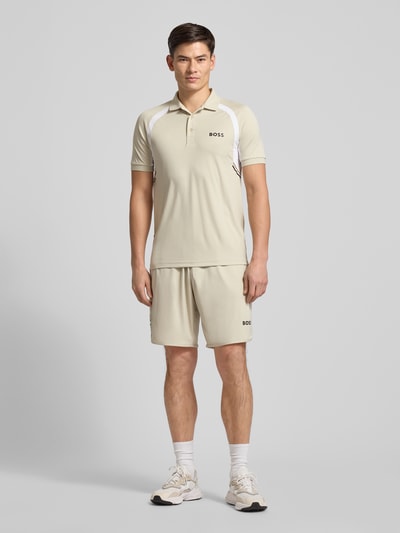 Männermodel trägt Slim Fit Poloshirt mit kurzer Knopfleiste Modell 'PL_TOC SPIN CB' von BOSS Green, Optik: Unifarben, Label-Print, Polokragen, Kurzarm, Materialverarbeitung: Jersey, Ganzkörperansicht von vorne.