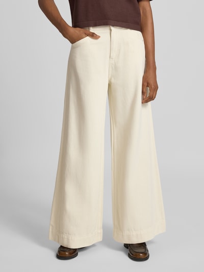 Frauenmodel trägt Wide Fit Jeans mit Logo-Detail Modell 'Eila' von JOOP! in Creme mit weitem Bein aus reiner Baumwolle, Nahaufnahme Oberkörper, Damen Jeans mit Eingriff- und Gesäßtaschen, Knopf- und Reißverschluss, Kontext: Bundweite 41 cm, Innenbeinlänge 80 cm.