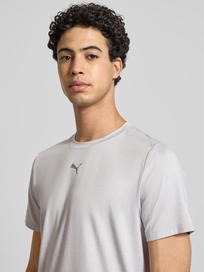Männermodel trägt Regular Fit T-Shirt mit Rundhalsausschnitt von PUMA PERFORMANCE aus Baumwoll-Viskose-Mix, Logo-Print, Nahaufnahme Oberkörper.