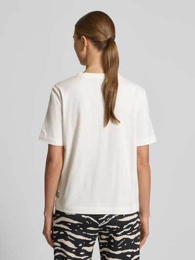Modelka kobieca nosi T-Shirt z 1/2-rękawem od Marc Cain z czystej bawełny, prosty krój, biały kolor, widoczne logo, widok całej sylwetki od tyłu.