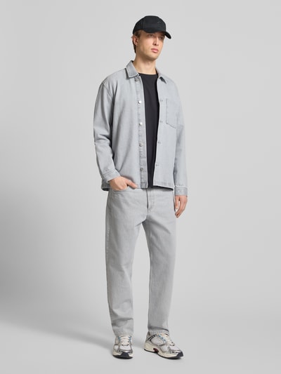 Männermodel trägt Regular Fit Hemdjacke aus reiner Baumwolle von Marc O'Polo Denim in Denim-Optik mit Umlegekragen, Ganzkörperansicht von vorne.