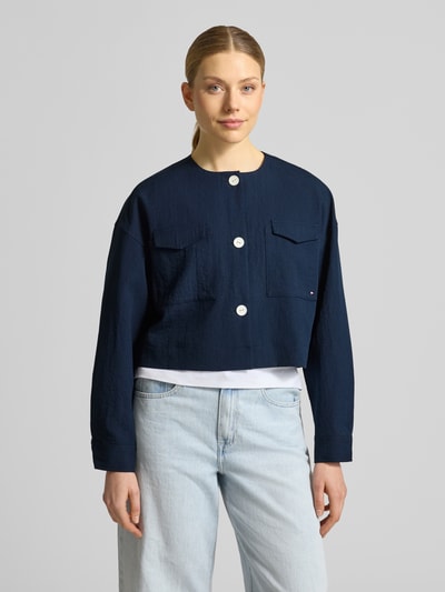 Frauenmodel trägt Boxy Fit Kurzblazer aus Viskose-Mix von Tommy Hilfiger in Optik: Unifarben, dunkelblau, mit Logo-Stitching, Ganzkörperansicht von vorne.