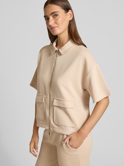 Frauenmodel trägt Jacke mit Umlegekragen von Christian Berg Woman aus Elastischer-Material-Mix, Gerader-Schnitt, Reißverschluss, 1/2-Arm, AufgesetzteTaschen, sandfarben, glatte Textur, Nahaufnahme Oberkörper von vorne.