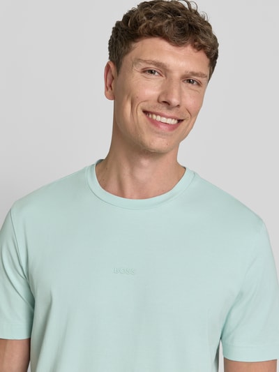 Männermodel trägt Relaxed Fit T-Shirt aus Baumwoll-Mix Modell 'TCHUP' von BOSS Orange, unifarben, Label Print, Jersey, Nahaufnahme Oberkörper.