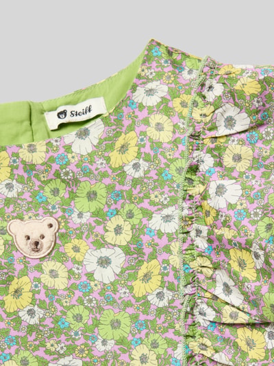 Mädchen trägt Regular Fit Kleid mit Rüschenbesatz von Steiff, Floraler-Print, Reine Baumwolle, Ärmelloses-Design, Rundhalsausschnitt, Nahaufnahme Oberkörper.
